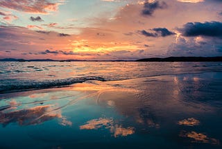 Warm redish glow in the clouds over the ocean at sunset