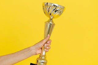 A person holding a trophy with one hand