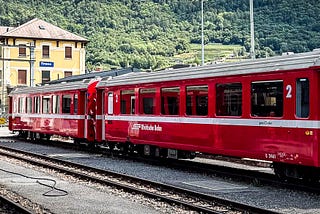 Bright red train cars in a line at the train station.