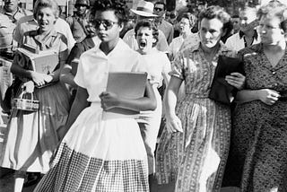 Elizabeth Eckford walks into Little Rock High in 1957 while white students taunt her