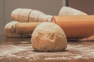Bread dough on a floured surface; rolling pin