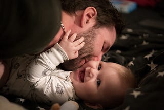 A photo of a Dad playing with his baby