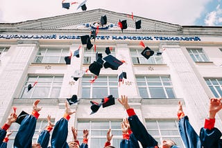 Students throwing their graduation caps in the air.