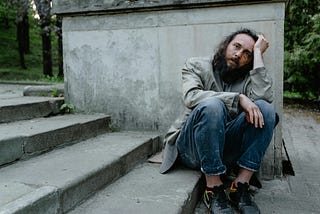 Homeless man sitting on steps