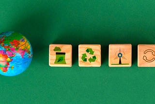 Symbols of sustainability etched on cubes alongside a mini globe