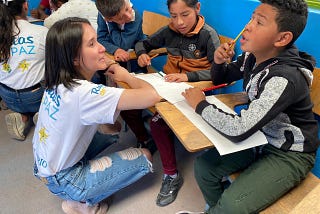 Somos CaPAZes volunteers tutoring a few young children)