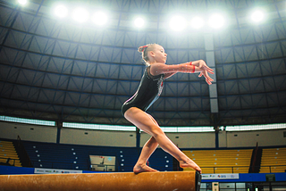 Young gymnast performing on the balance beam