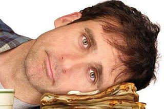 Poster art for the film Dan in Real Life. Steve Carell with dead eyes and 5 o’clock shadow evidently photoshopped to appear as if he has his head passively pressed down on a pile of buttery, syrupy pancakes.