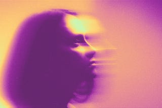 A visually disrupted, part blurred woman gazing from left to right in a trance. The image is saturated in bright purple and yellow gradient mapped colour tones.
