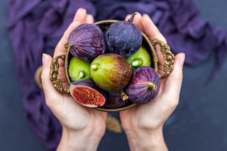 Closeup shot of a person holding fresh figs