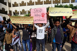 Yemeni children in a protest holding signs against the bombing