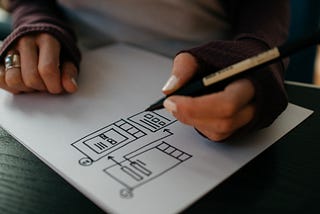 Closeup of a pair of hands sketching UI components on a sheet of paper
