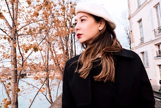 Portrait of author in Paris, wearing a beret, and looking out towards the Seine.