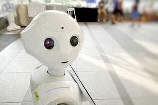 Robot made out of what looks like white plastic is looking at the reader