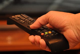 Hand holding a TV remote control device