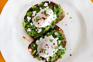 Mashed sweet peas on toast with poached eggs on top.