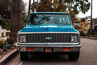 Front view of an older, blue Chevy truck