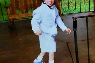 A young boy in a seersucker suit and roller skates