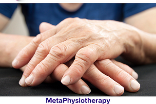 Two elderly hands are resting on the table