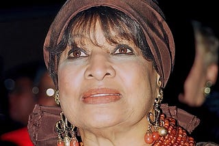 Civil rights activist Delores Tucker is pictured at a 1996 Washington D.C. Black caucus event. Tucker is wearing a brown head scarf, red lipstick and gold and red dangling earrings.