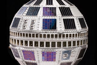 Color photo against black background of Telstar satellite