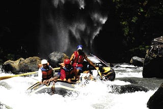 Guide and two clients in whitewater raft.