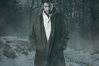 Vampire standing in the woods wearing a long overcoat in the snow. G. K. Hunter