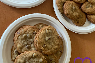a plate of chocolate chip cookies with a purple heart in the corner