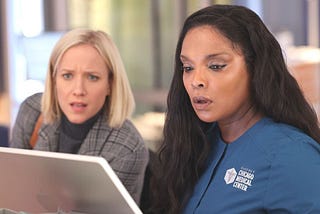 Asher and Maggie look surprised at a computer in Chicago Med season 9