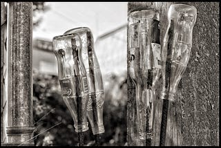 Four upside down bottles covering sharp rebar ends.