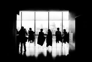 Silouette of business people at a comference table.