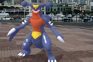 My Pokémon buddy standing on the wharf with many yachts and the Skytower in the background.