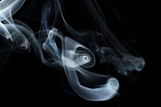 Billowing smoke on a plain black background. Photo of smoke by Howard Senton on Unsplash