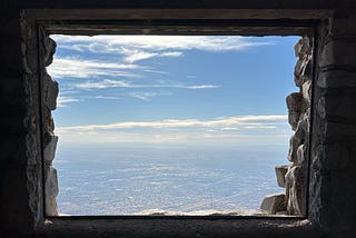 View from a stone window in a Civilian Conservation Corps building atop Sandia Crest, looking west over Albuquerque and the Rio Grande. Photograph by David O’Hara and copyright 2024.