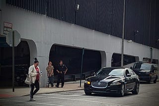 A prisoner being transported with police escort.