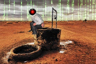 A lonely mud-brick well in a brown desert. It has been modified to add a ‘caganar’ — a traditional Spanish figure of a man crouching down and defecating — perched on the edge of the well. The caganar’s head has been replaced with the menacing red eye of HAL9000 from Kubrick’s ‘2001: A Space Odyssey.’ The sky behind this scene has been blended with a ‘code waterfall’ effect as seen in the credit sequences of the Wachowskis’ ‘Matrix’ movies. Image: Cryteria (modified) https://commons.wikimedia.or