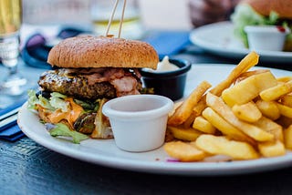 A burger and fries on a white plate.