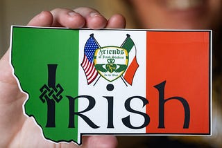 A hand holding a sign that says “Irish.”