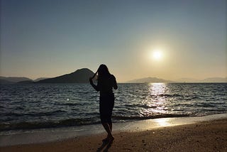 Nostalgic silhouette of a young girl walking on a beach