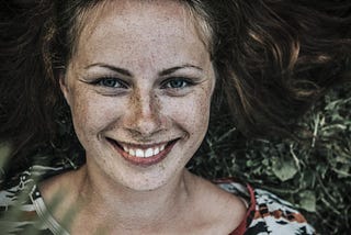 Portrait of young woman, smiling. freckles.