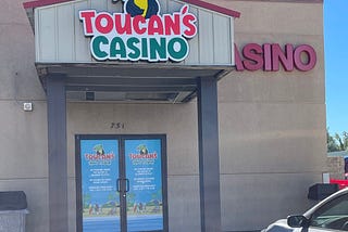 Picture of Toucan above the door of a casino named Toucan’s Casino.