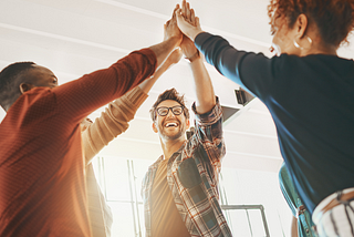 A group of diverse professionals coming together, symbolizing the unity and collaboration fostered by the Leadership Code of Conduct.