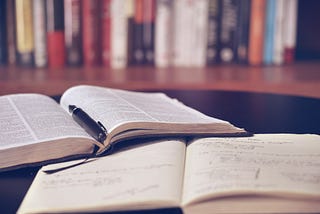 One book and one notebook on the desk.