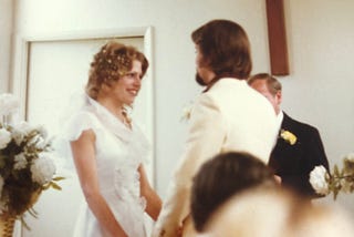A man and a woman at the alter saying their vows in their wedding