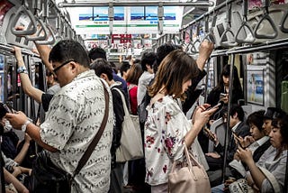 Everybody checking their phone on a local train.