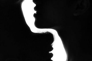 High contrast black and white portrait of the profiles of a man and woman, symbolic of yin and yang/feminine and masculine energy