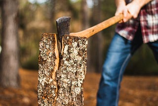 A person with an ax chopping wood.