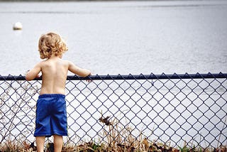 A little boy looking at the lake