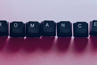 ROMANCE in keyboard letters on a light pink background