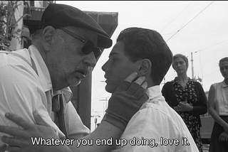 Black and white screenshot from the film: Cinema Paradiso directed by Giuseppe Tornatore. An older man holds a young boy’s face. The subtitle reads: whatever you end up doing, love it.